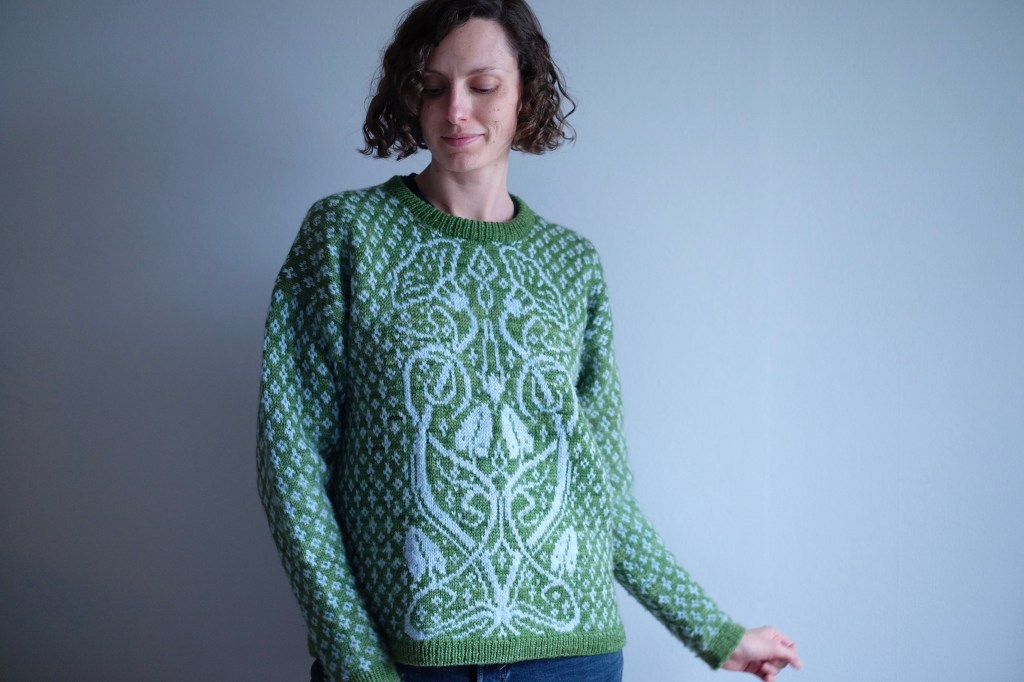 Dianna poses in the sweater, half-smiling with her left arm partly extended. The sleeve is relatively full in the upper arm and quite fitted at the forearm.